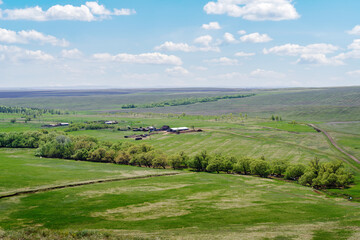 Fototapeta na wymiar Spring rural landscape with a farm, fields and a country road. Photo taken near the village of Voskresenovka, Orenburg region, Russia