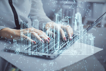 Double exposure of woman hands typing on computer and buildings drawing. Smart-city concept.