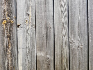 The texture of wooden planks arranged vertically. The color of the boards is gray with yellow splashes.