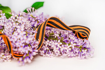 Beautiful floral background with St. George ribbon and lilac. Spring holiday banner with a place for the text