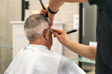 Close up of an old man's haircut with a razor from a barber