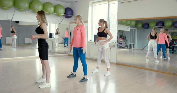 Female fitness trainer leading a class at the gym