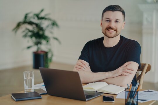 Handsome successful freelancer working with laptop at his workplace