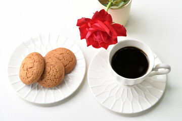 A cup of black coffee, cookies and a rose