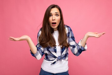 Portrait photo of young surprised astonished beautiful brunette woman with sincere emotions wearing...