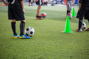 Obraz premium Boys Soccer ball tactics on grass field with cone