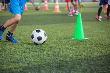 Obraz na płótnie Canvas Boys Soccer ball tactics on grass field with cone