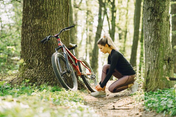 Naklejka premium Woman riding a mountain bike in the forest
