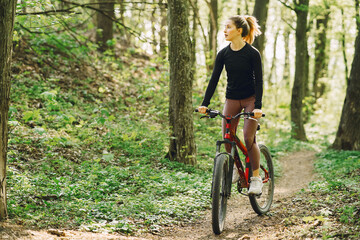 Fototapeta na wymiar Woman riding a mountain bike in the forest