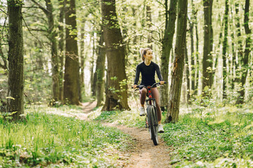 Obraz premium Woman riding a mountain bike in the forest
