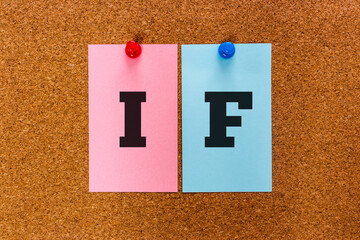 Conceptual 2 letter keyword IF on multicolored stickers attached to a cork board. If used in conditional sentences in English language