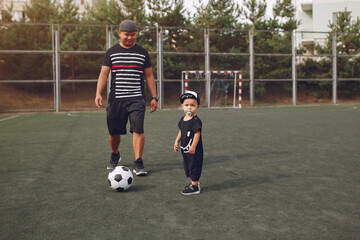Father with little son playing a football