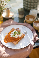 Delicious breakfast on terrace with omelette and apricot sauce and fresh goat cheese. Light summer meal.