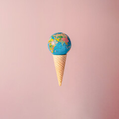 Ice cream cone with a globe-shaped ball on it. Minimal summer and travel concept. Pastel beige...