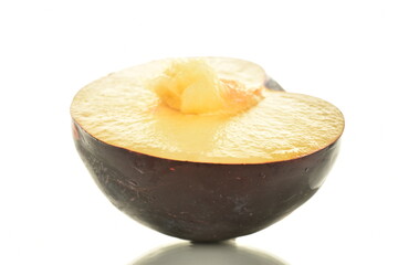 One half of sweet tasty dark purple plum, close-up, isolated on white.