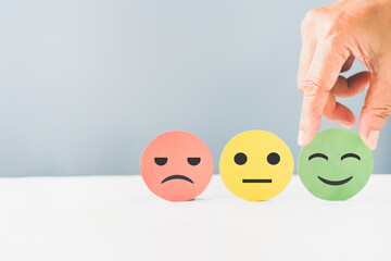 hand choose green paper cut, happy smiling face for mental health assessment ,positive thinking, world mental health day ,customer review, experience, satisfaction survey concept
