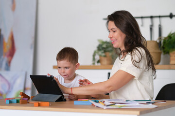 Mother with young boy using digital tablet.happy mom and baby play educational online games on the tablet.