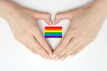 Women's hands create a heart, inside an LGBT flag on a white background.It can be used as a border of pride of the gay and lesbian community,for the design of leaflets,greeting cards