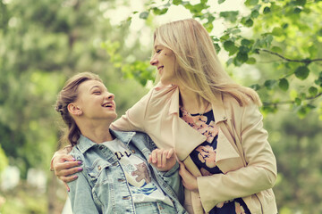 happy mother with her daughter hugging a teenager in the summer. Caring happy mother enjoy day with teenage girl child, laugh have fun. Mother giving her daughter advice.