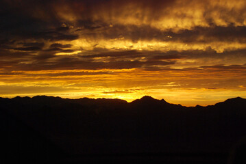 燃えるような夕焼けと山のシルエット