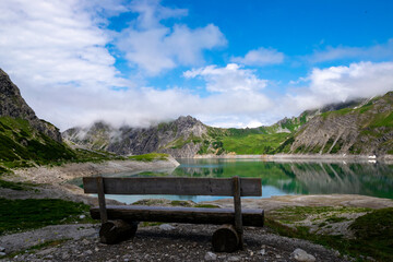 Fototapeta premium wooden bench next to the Lünersee (Vorarlberg, Austria)