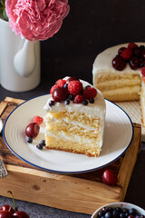 Piece of cake with berries. Side view, peonies.
