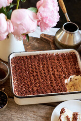Homemade tiramisu. Peonies, coffee, blueberries. Side view.