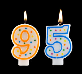 Burning birthday candles isolated on black background, number 95