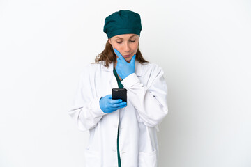 Surgeon caucasian woman in green uniform isolated on white background thinking and sending a message