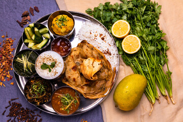 Indian food plate, basmati rice, paratha bread, lassi, potato, goya, beans curry, spinach curry