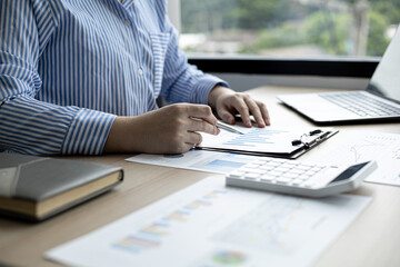 The saleswoman is reviewing the monthly sales summary document prepared to bring to the department meeting with the sales manager, monthly sales summary meeting in order to plan the next month's sales