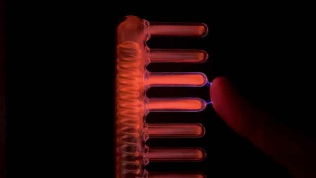 Video of High frequency current produced by Comb tube of High Frequency D'arsonval Device. Electricity concept. Hair micro current therapy. Hair care, hair loss. High frequency electrotherapy 