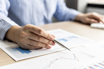 The businesswoman points to the company financial summary prepared by the finance department, she is checking the accuracy of the monthly financial statements. Concept of company financial management.