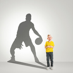 Dreams about big and famous future. Conceptual image with little boy and shadow of fit male...