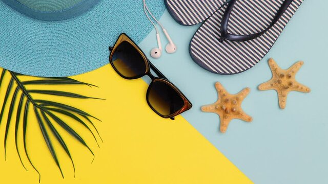 Summer background. Beach accessories appear on a yellow and blue background. The seashells are spinning. Summer and vacation concept. Stop motion animation. Copy space.