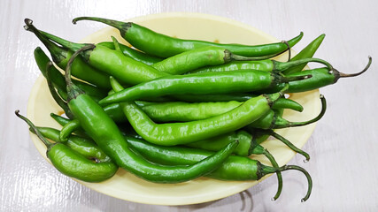 Green peppers in the threshing basket on wooden table