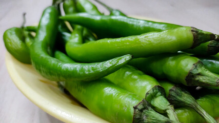 Green peppers in the threshing basket on wooden table