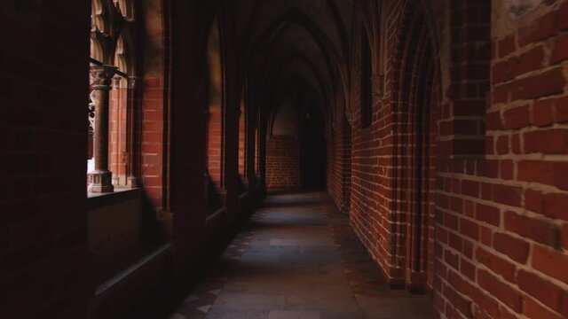 Inside Teutonic castle in Malbork. Brick walls and rib-and-cross vaults in dark corridor