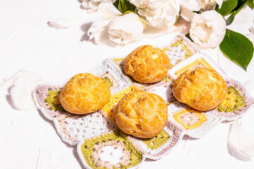 Profiteroles with blueberries. Custard cakes, Eclair, cream puff on a wooden stand