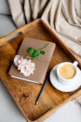 Notepad, pencil and a cup of coffee on a tray.