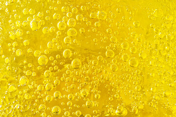 Yellow bubble of water on ice in a glasses beer or whisky. background texture.