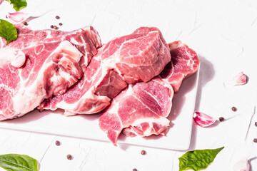 Raw pork meat, sliced cuts with dry sumac, fresh garlic and basil leaves