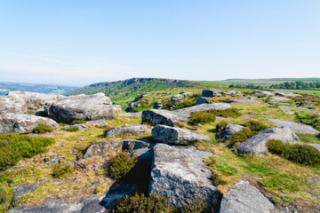 Fototapeta na wymiar Gritstone rocks large and small scattered along the top of Baslow Edge
