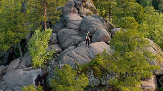 The traveler is climbing on the top of the wild mount The Krasnoyarsk Pillars