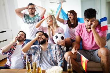 Shocked, frustrated friends watching football game at home