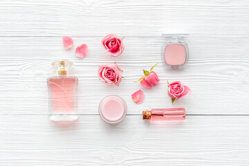 Cosmetics with rose oil essence. Face cream lotion and flowers, top view