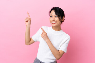 Young Vietnamese woman isolated on pink background pointing with the index finger a great idea