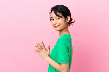 Young Vietnamese woman isolated on pink background scheming something