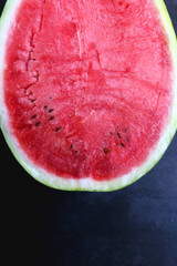 Fototapeta na wymiar Half of watermelon on dark background. Top view.