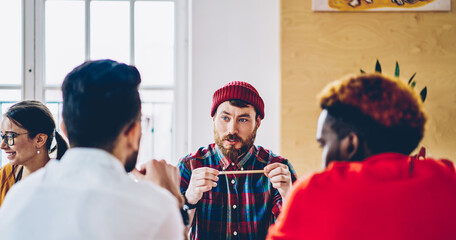 Professional team of male creative employees dressed in casual wear discussing productive ideas to create business plan for startup project collaborating at meeting table, concept of brainstorming